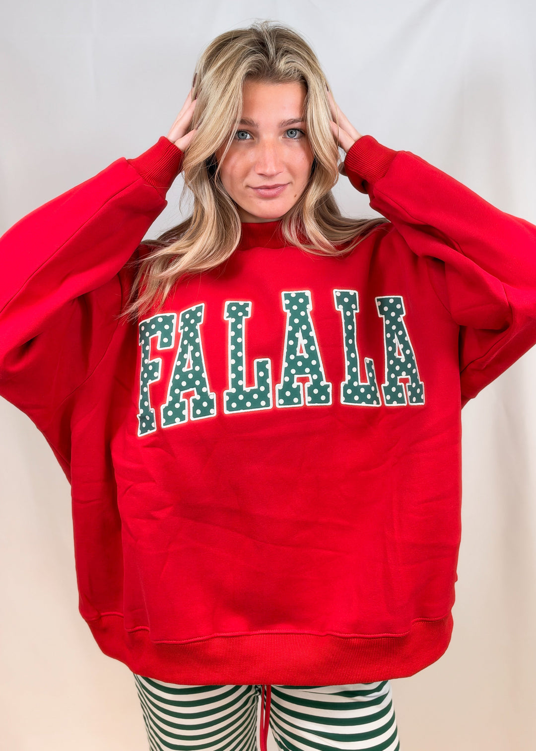 Woman wearing red mock neck sweatshirt with &