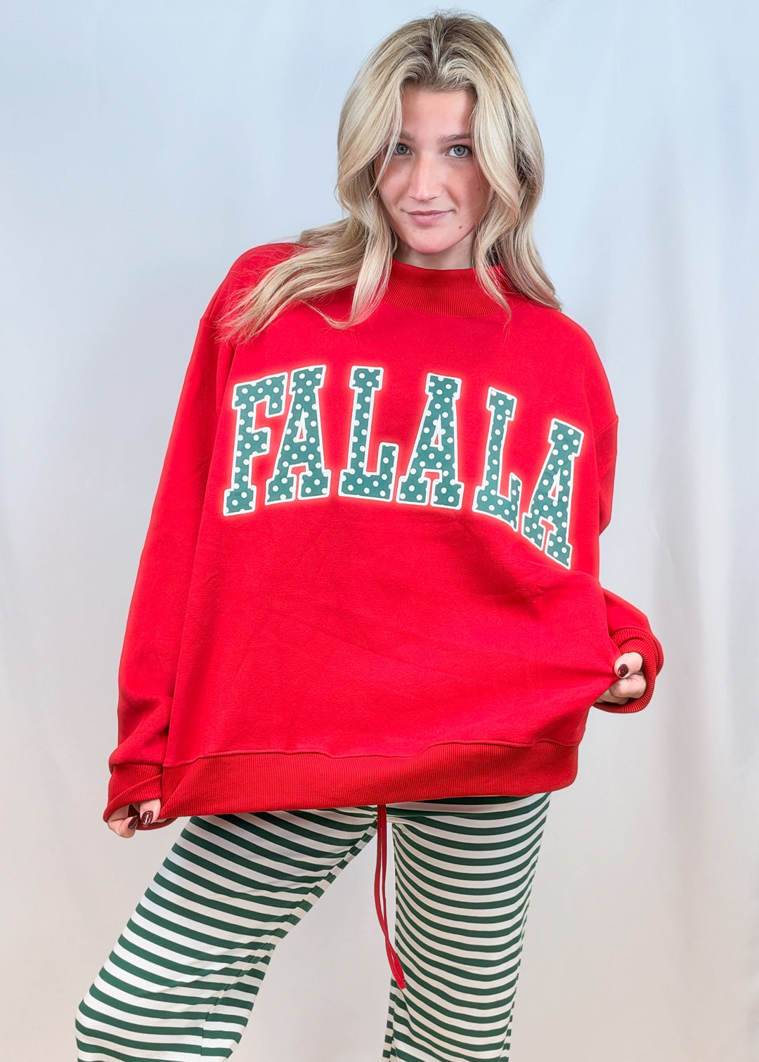 Woman wearing red mock neck sweatshirt with &