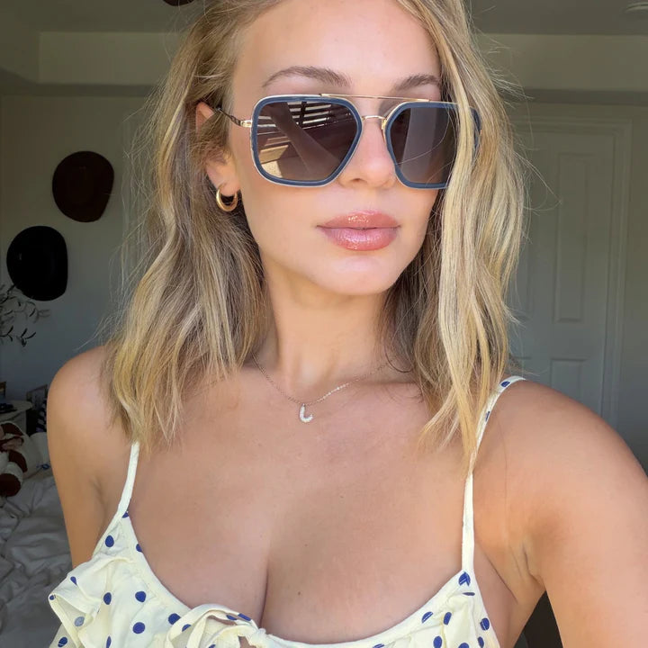 Woman wearing sunglasses and a polka dot top indoors