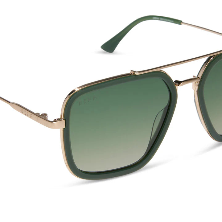 Sunglasses with gold frame and green lenses on a white background