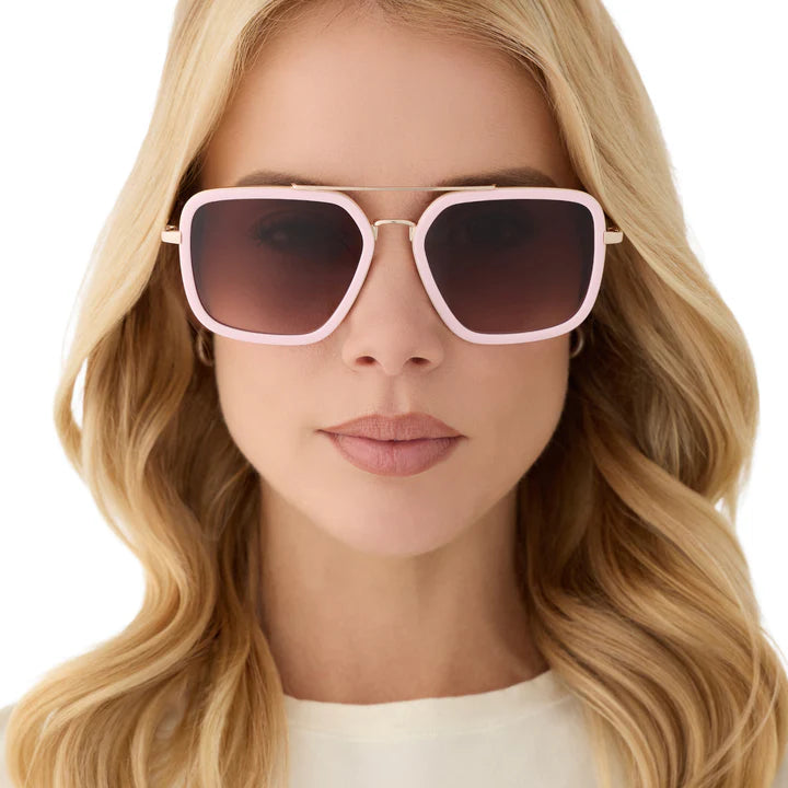 Woman wearing pink sunglasses with a neutral background