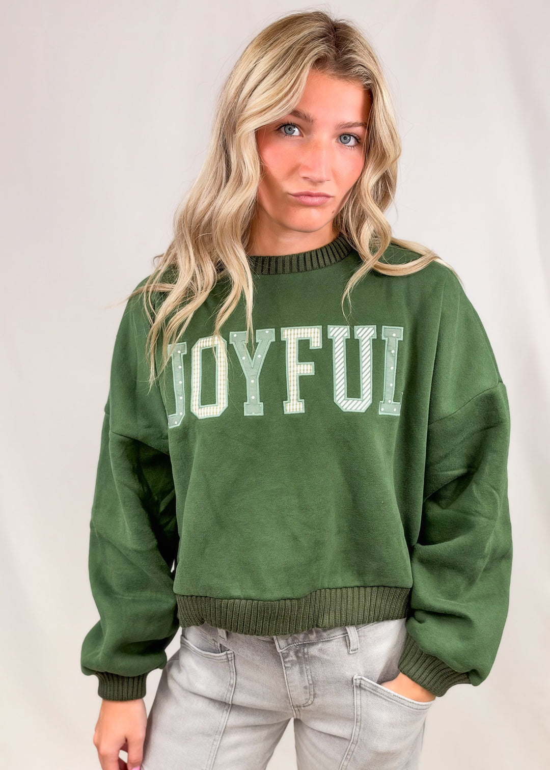 Woman wearing green sweatshirt with &