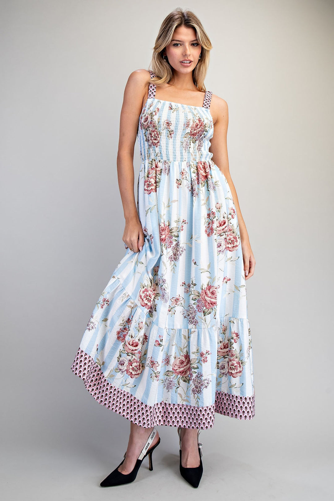 Woman wearing blue floral dress on plain background