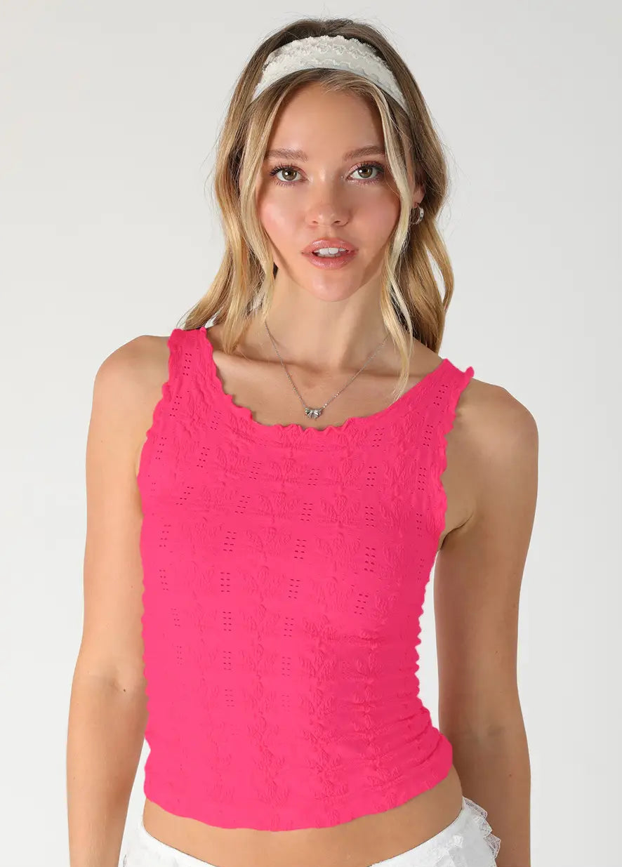 Woman wearing a bright pink tank top on a white background