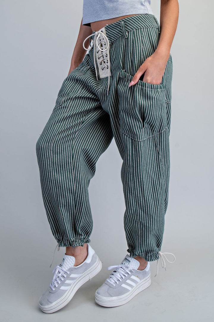 Woman wearing stripe green pants on plain background