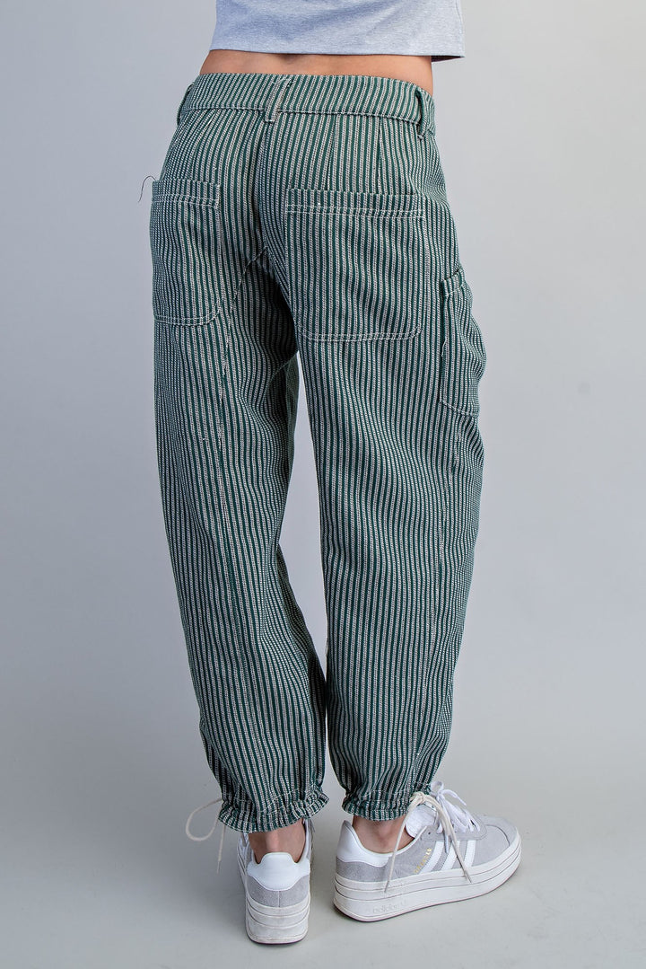 Green striped pants worn by a person on a gray background