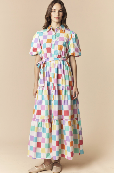 Woman wearing a colorful checkered dress on a beige background