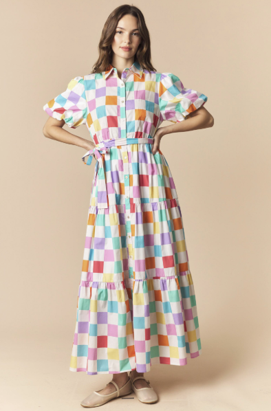 Woman wearing a colorful checkered dress on a beige background