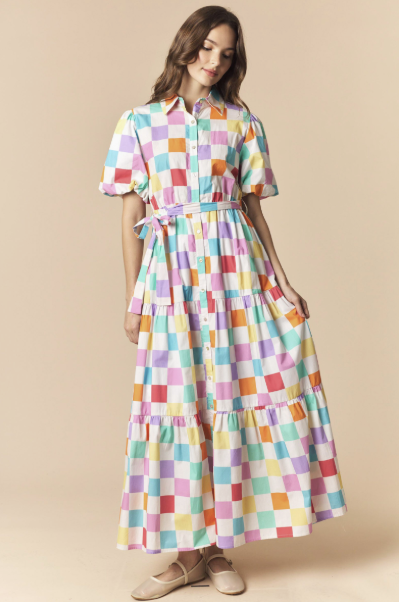 Woman wearing a colorful checkered dress on a beige background
