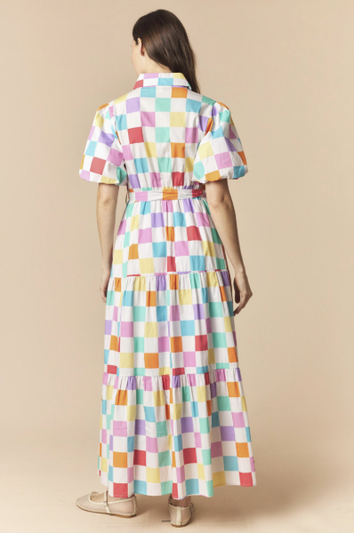 Woman wearing a colorful checkered dress on a beige background