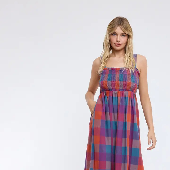 Woman wearing plaid dress on plain background