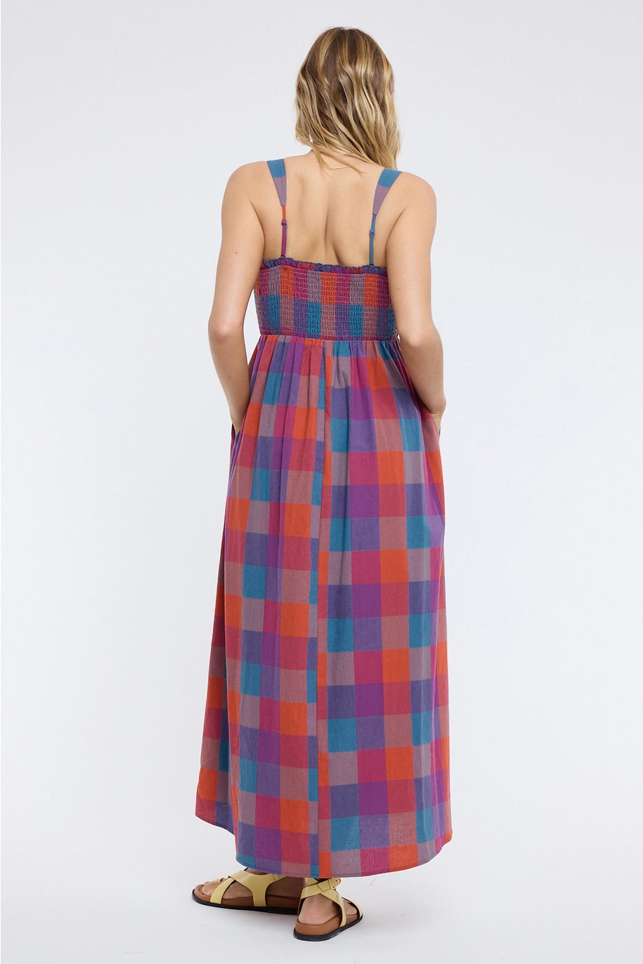 Back of woman wearing plaid dress on plain background