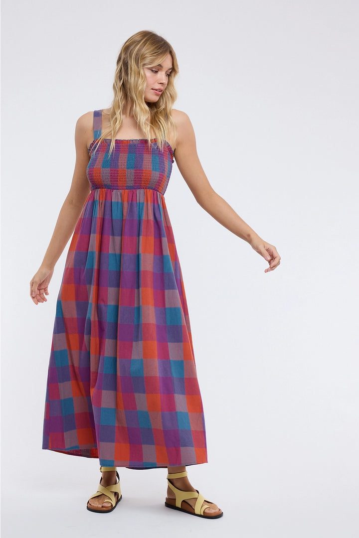 Woman wearing plaid dress on plain background