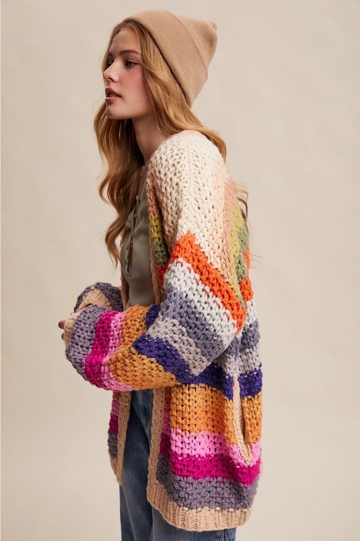 Woman wearing a colorful striped crochet cardigan on a beige background