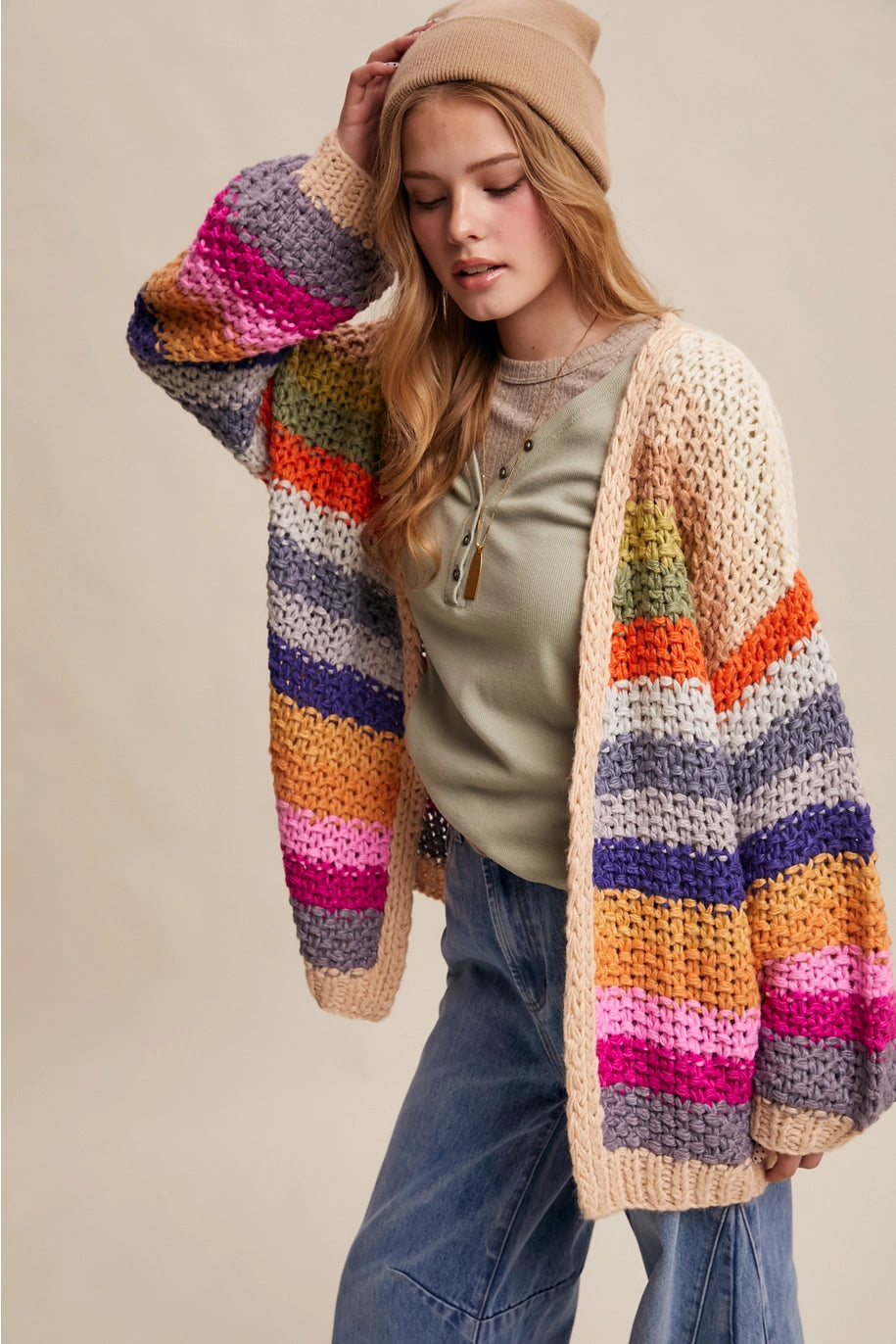 Woman wearing a colorful striped cardigan on a beige background