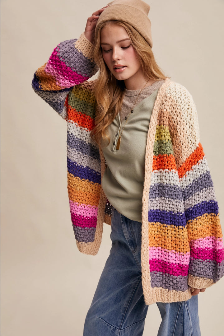 Woman wearing a colorful striped cardigan on a beige background