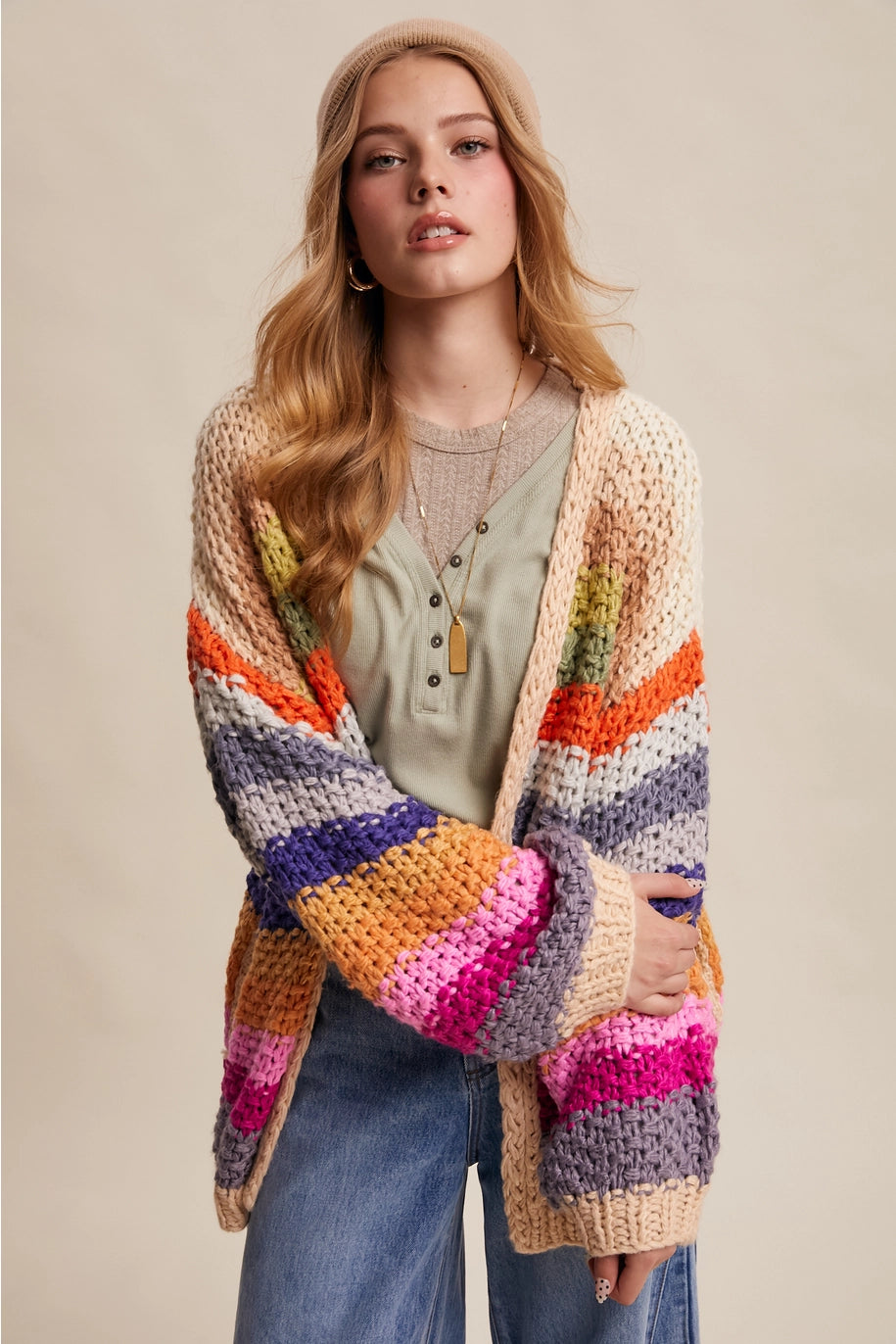 Woman wearing a colorful striped cardigan on a beige background