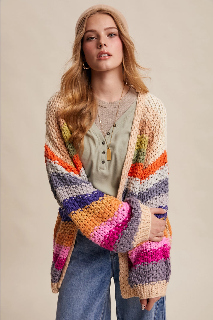 Woman wearing a colorful striped cardigan on a beige background