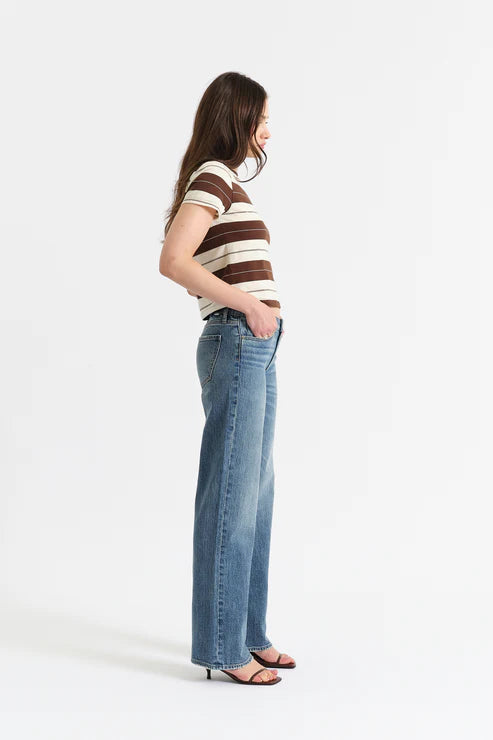 Woman wearing a striped shirt and jeans on a white background