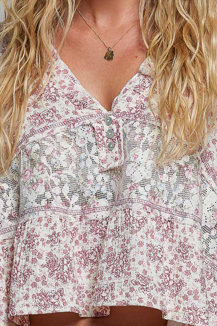 Floral patterned blouse with a necklace worn by a person
