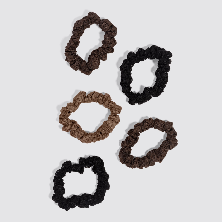 Five fabric scrunchies in assorted shades of brown and black, arranged on a light gray background.