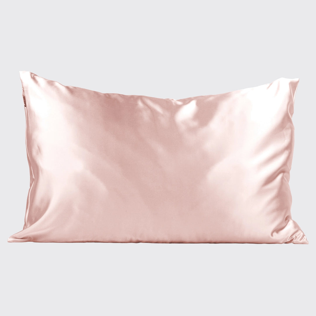 Blush satin pillowcase on pillow on plain background