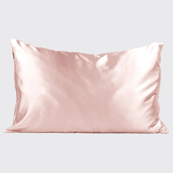 Blush satin pillowcase on pillow on plain background