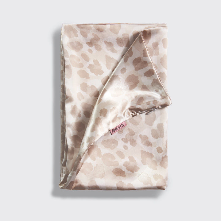 Satin leopard pillowcase folded on plain background