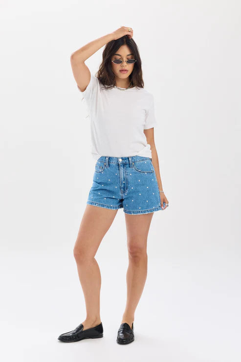 Woman wearing a white t-shirt and blue denim shorts on a white background