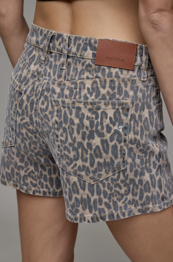Leopard print shorts with a brown leather patch on a gray background