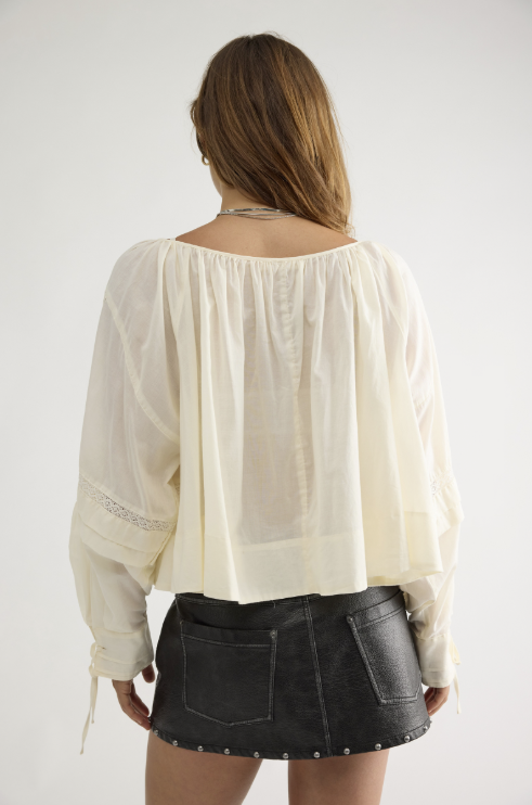 Woman wearing beige lace top and black skirt on white background