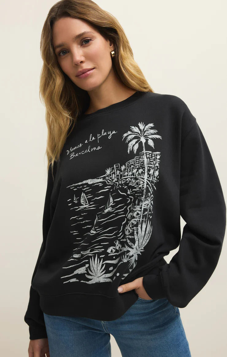 Woman wearing a black sweatshirt with a white graphic design on a plain background