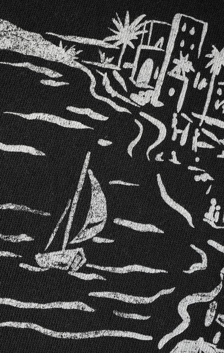 Black fabric with white embroidered design of a sailboat and buildings.