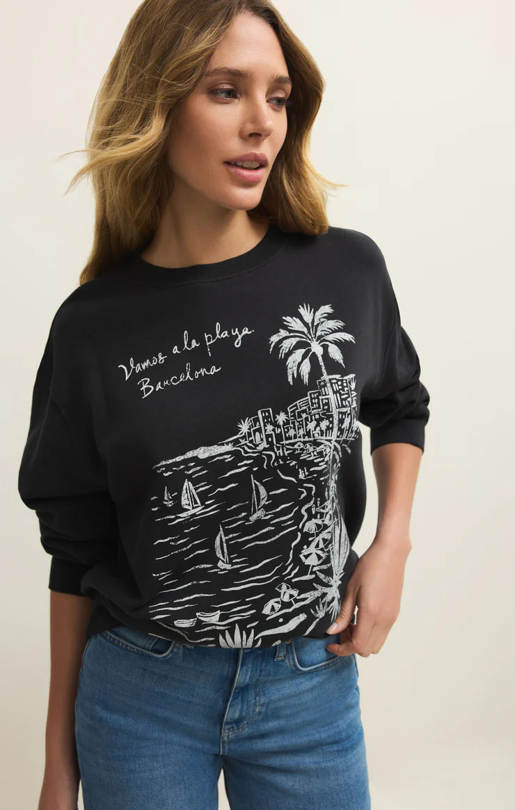 Woman wearing a black sweatshirt with a graphic design on a beige background