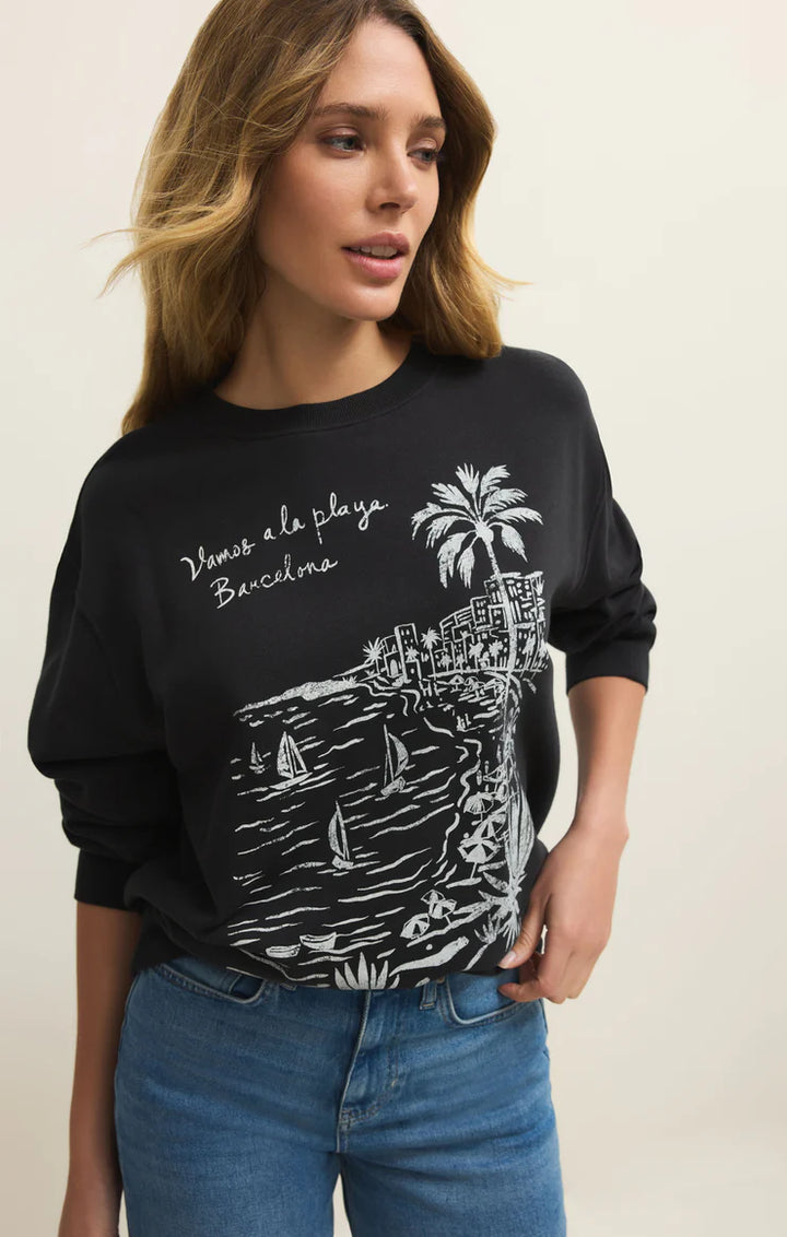 Woman wearing a black sweatshirt with a graphic design on a beige background