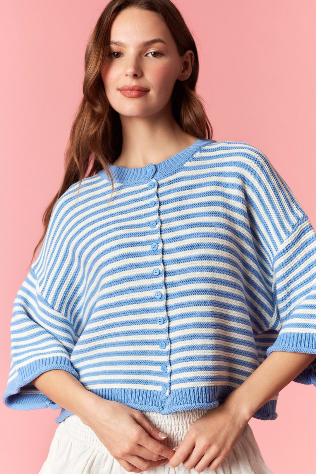 Woman wearing blue and white stripe short sleeve cardigan on plain background