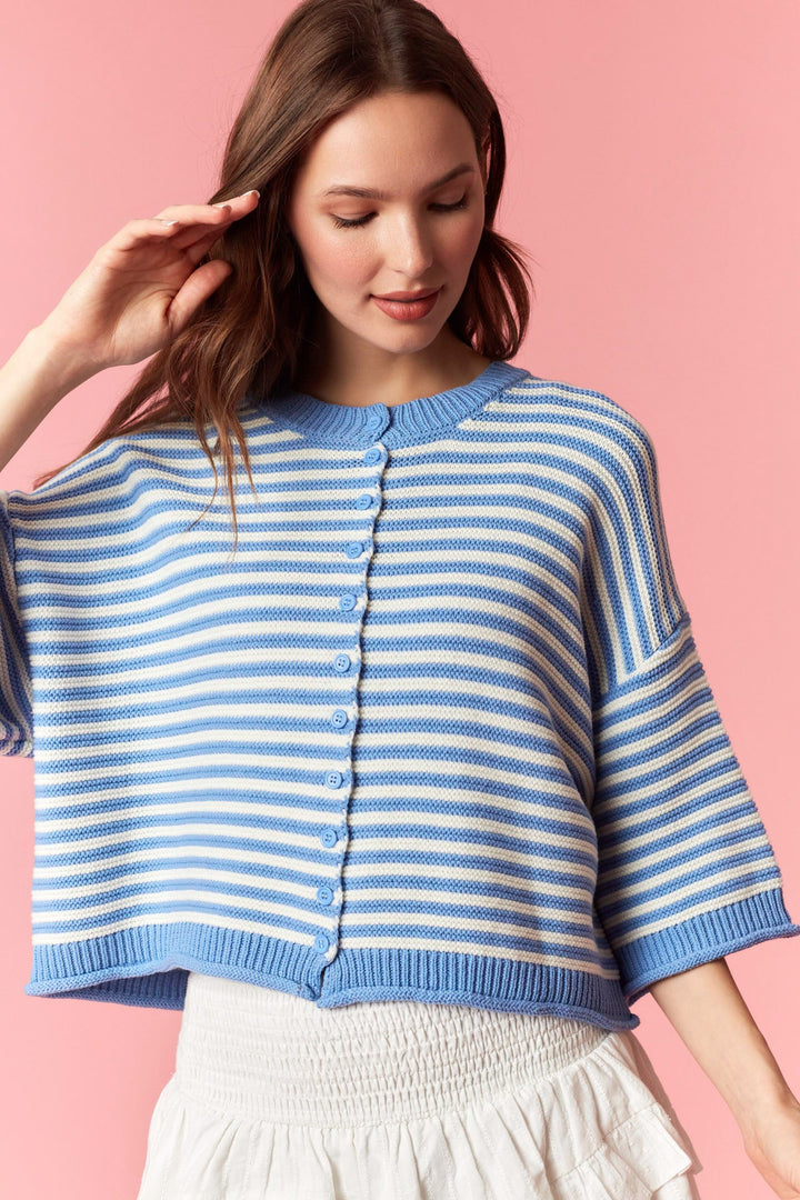 Woman wearing blue and white stripe cardigan on plain background