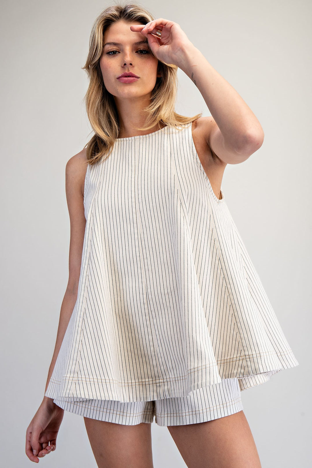 Woman wearing matching stripe set on plain background