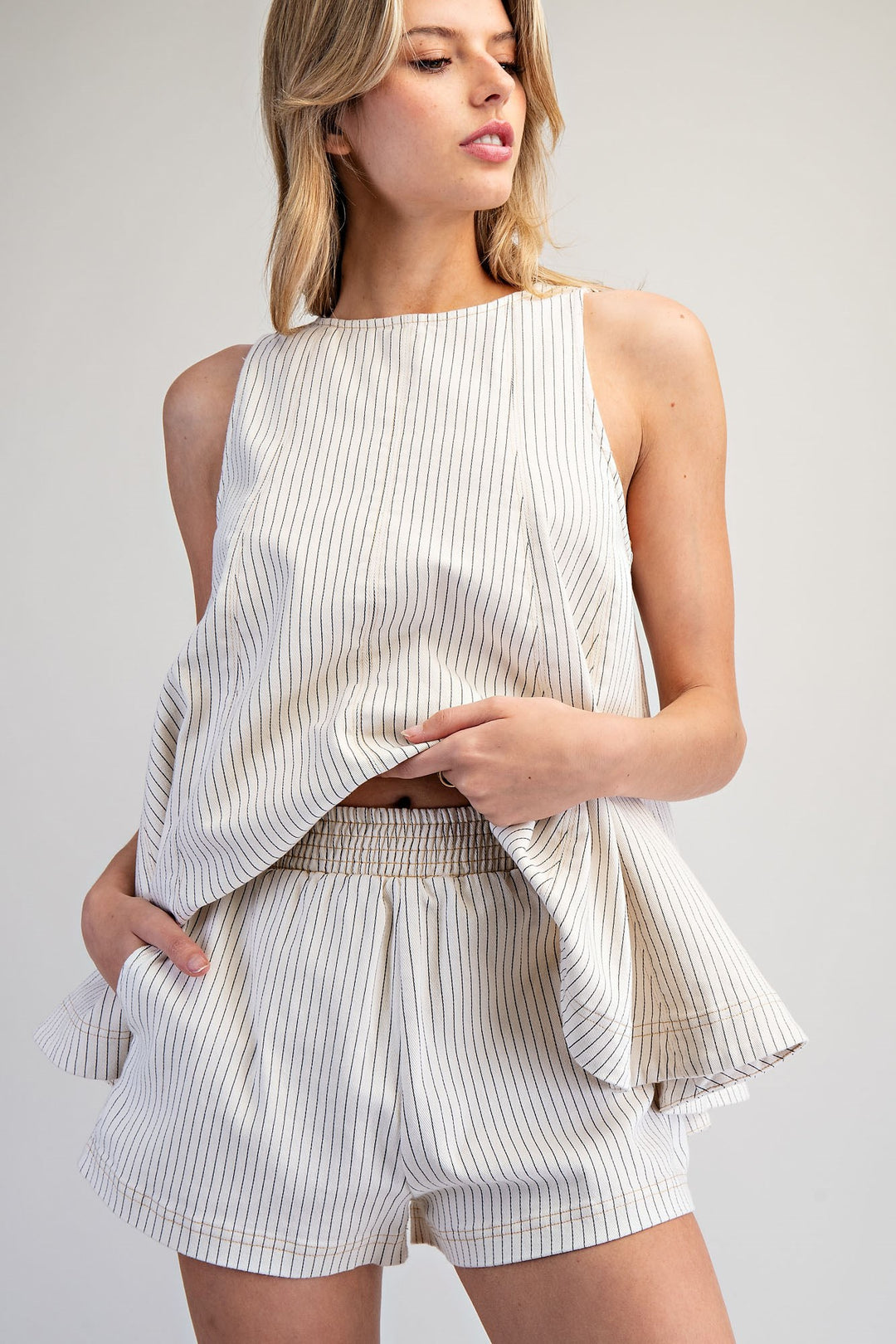 Woman wearing matching stripe set on plain background