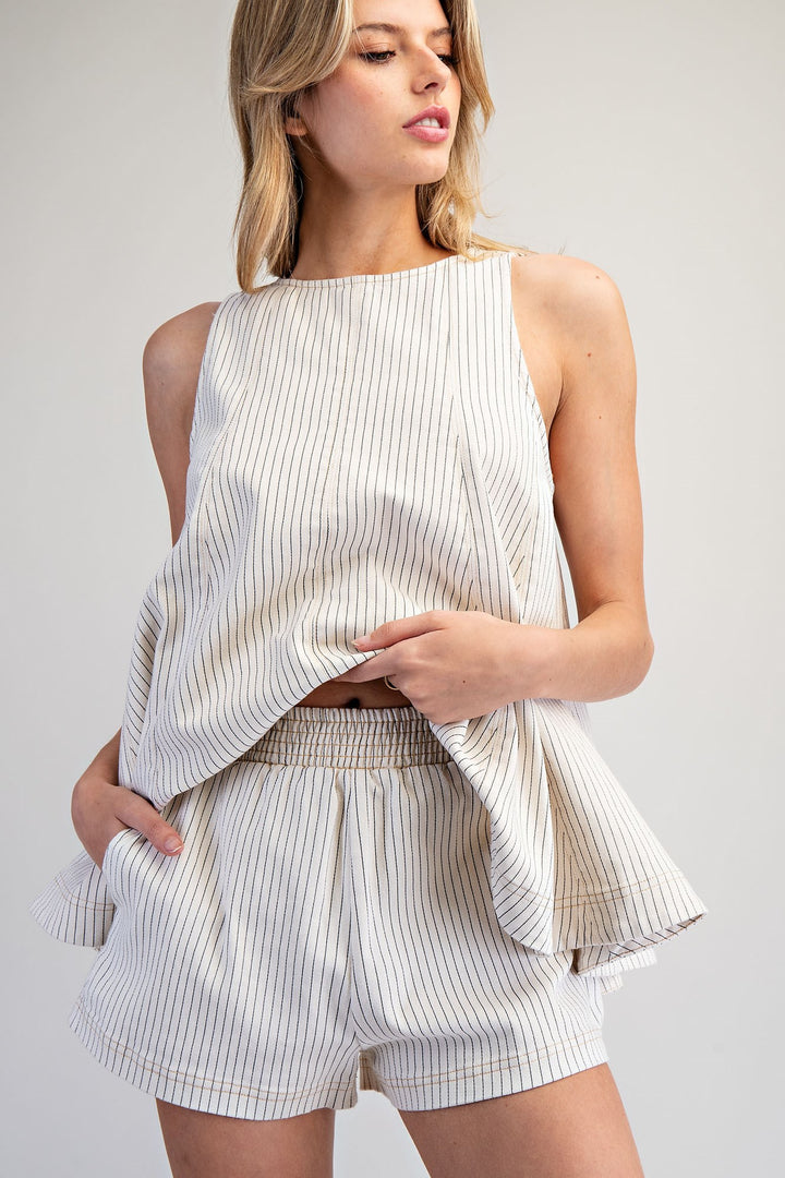 Woman wearing matching stripe set on plain background