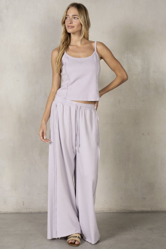 Woman wearing purple matching set on grey background