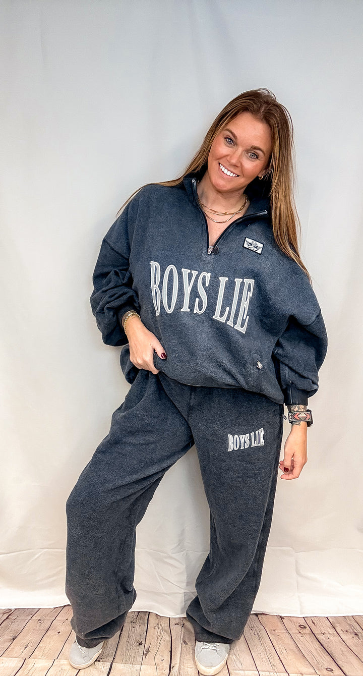 Woman wearing matching navy sweatsuit with &