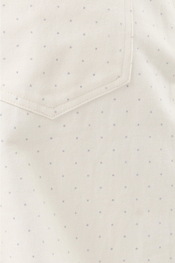 Close-up of  white pants with small gray dots and a pocket.