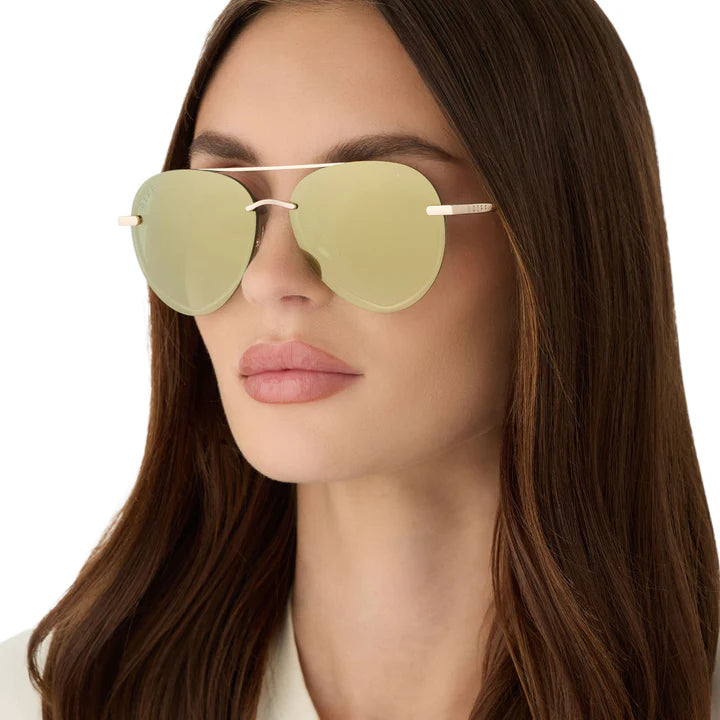 Woman wearing gold sunglasses on white background