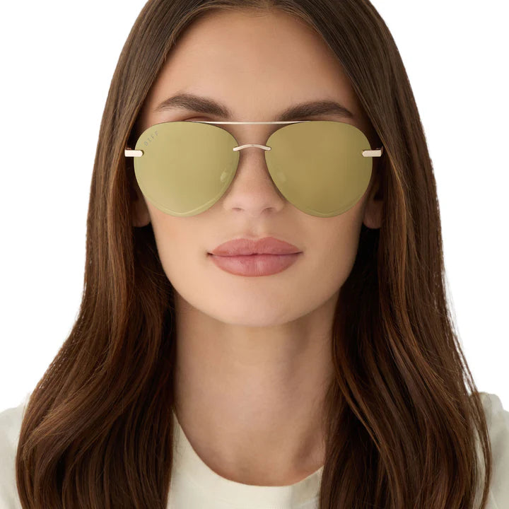 Woman wearing green sunglasses with a plain background
