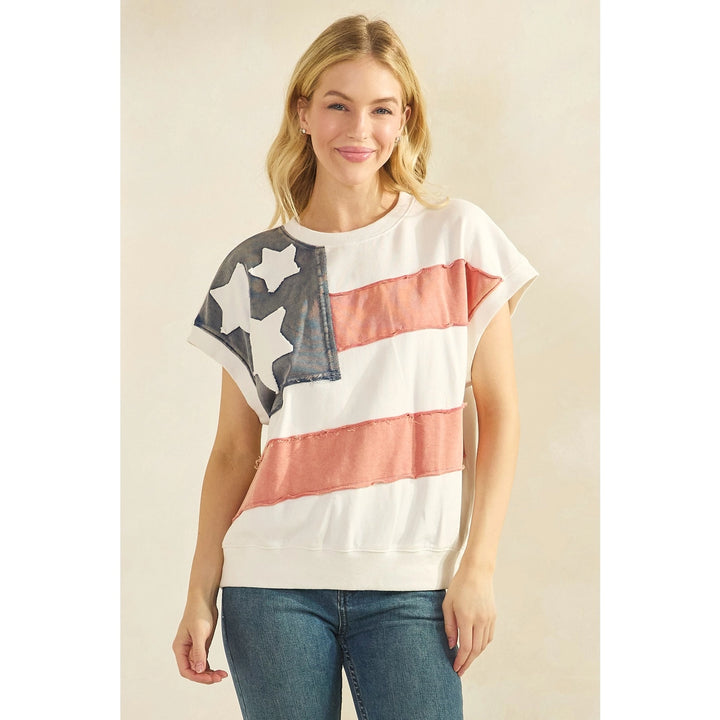 Woman wearing flag tee and jeans on plain background