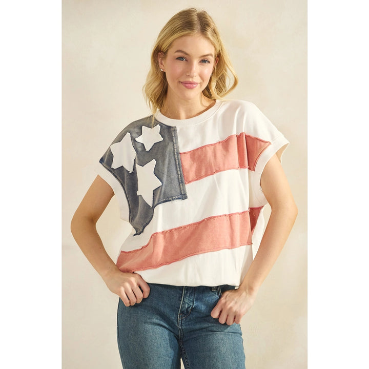 Woman wearing a t-shirt with an American flag design on a beige background