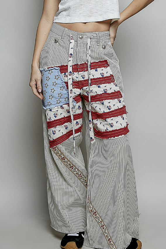 Woman wearing stripe pants with american flag on plain background