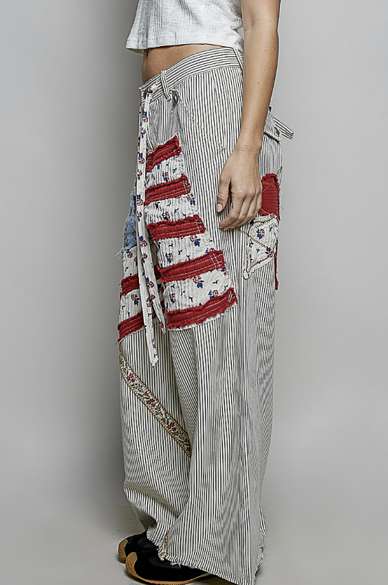Person wearing a long, patterned skirt with a plain background