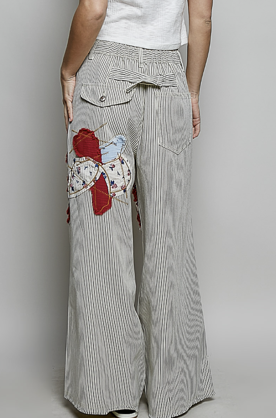 Striped pants with floral patchwork design on a plain background